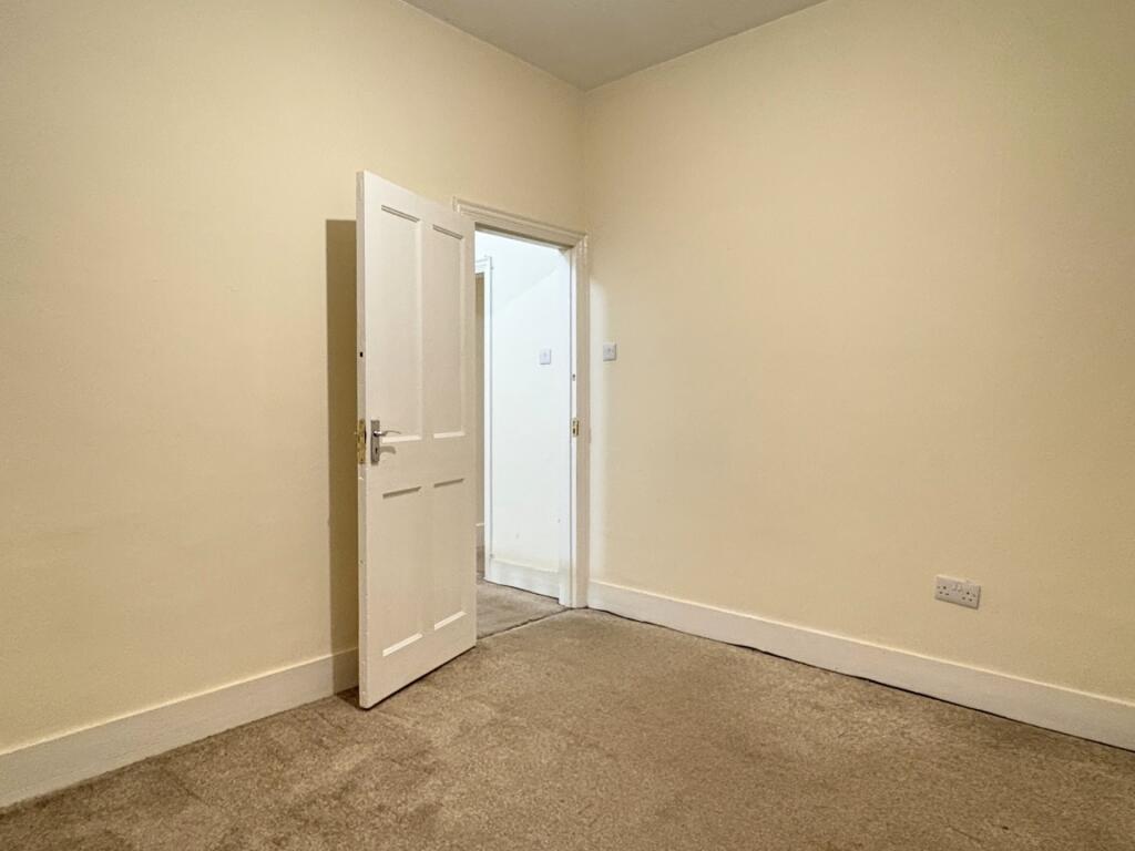 Bright, neutrally painted bedroom with clean ca...