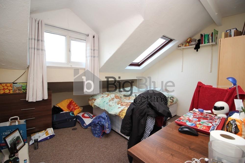 Cozy attic bedroom with a sloped ceiling, featu...