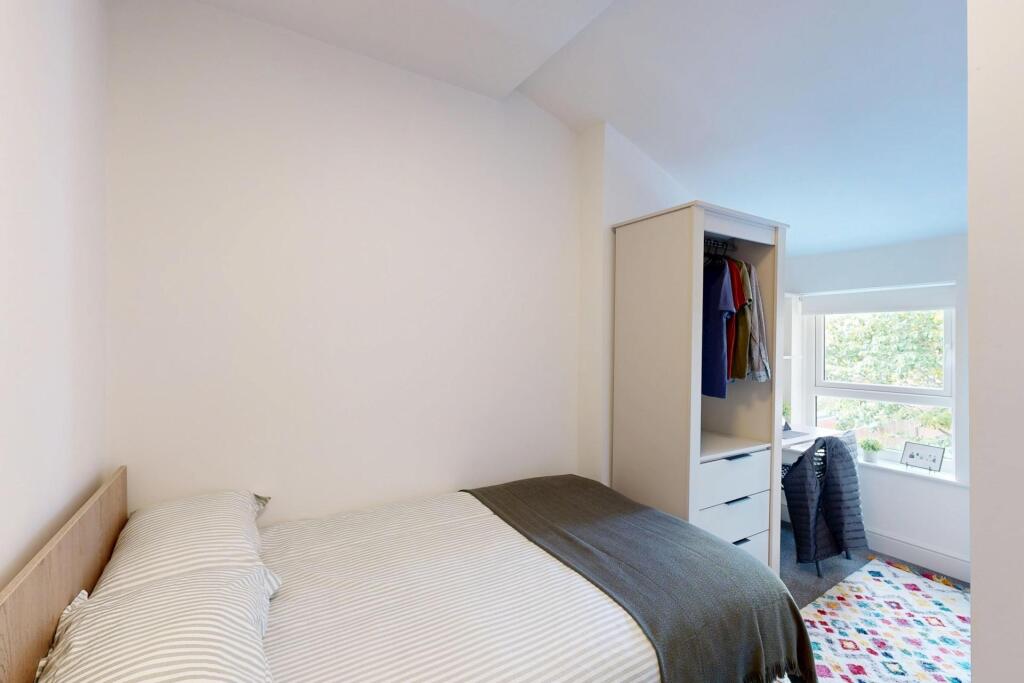 A bright and welcoming master bedroom featuring...