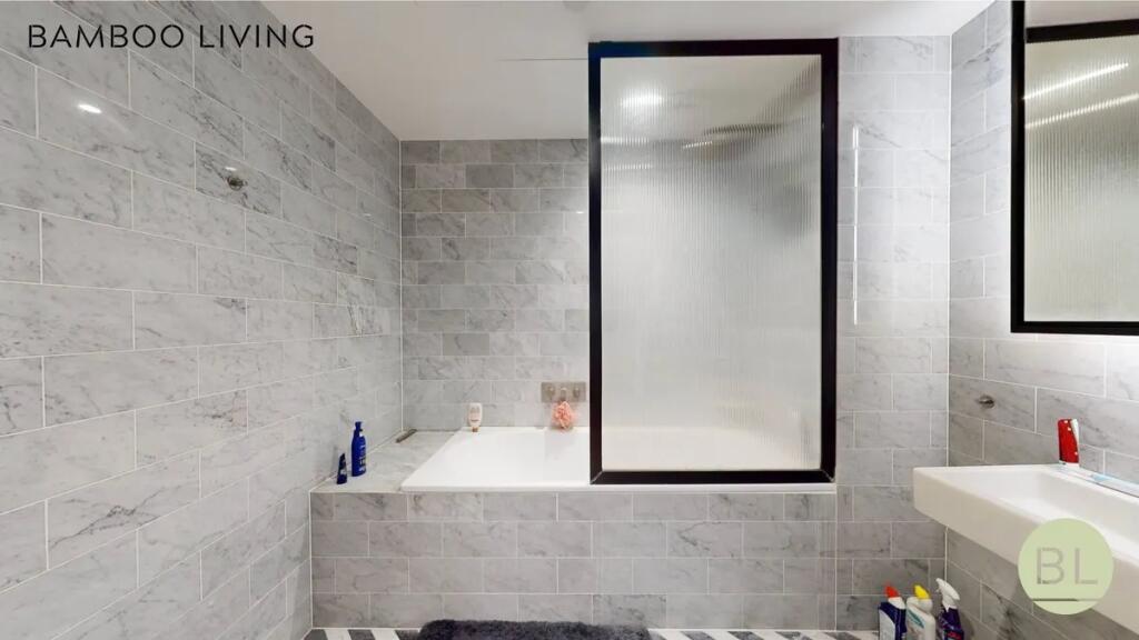 A modern bathroom suite featuring stylish grey ...
