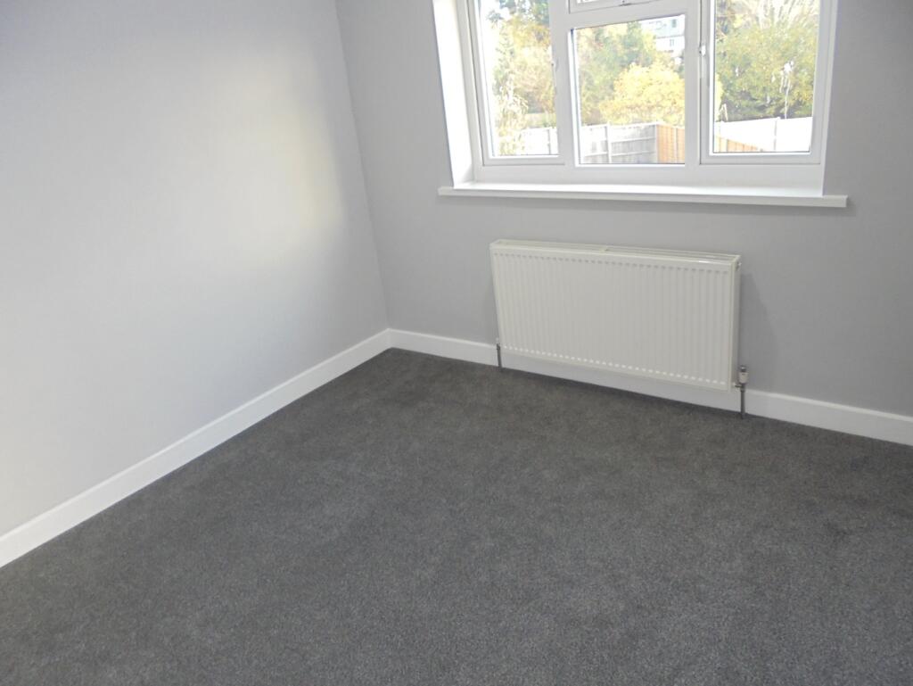 A bright and freshly carpeted double bedroom, p...