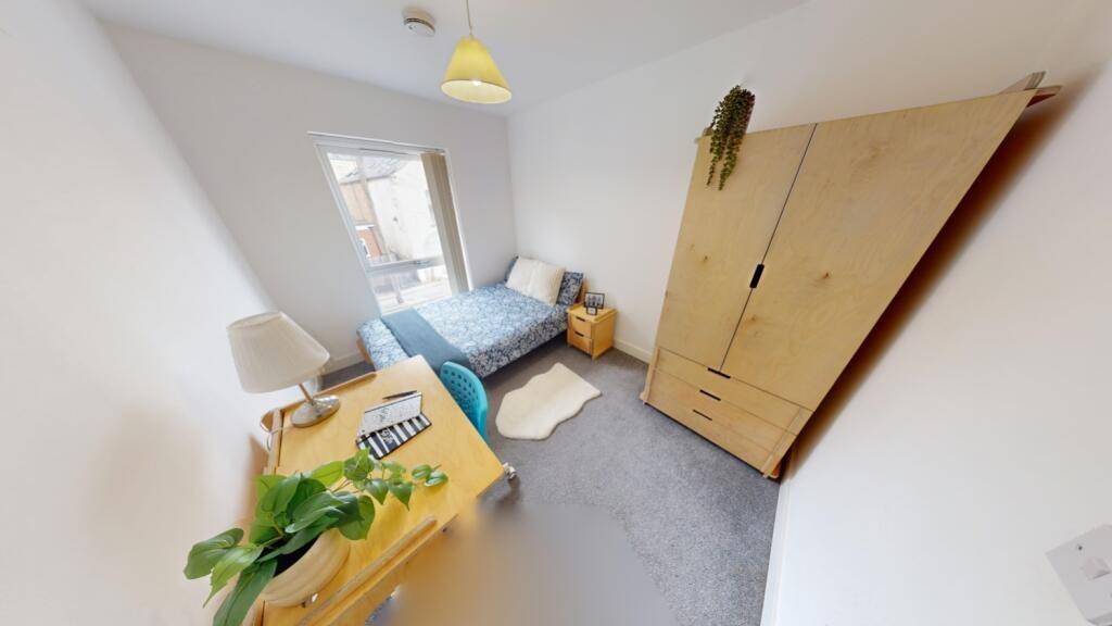 A bright and tidy single bedroom featuring a co...