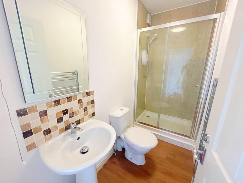 Bright and tidy bathroom featuring a modern sho...