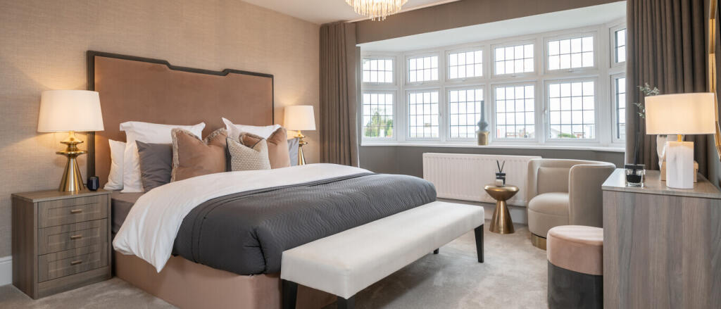 Elegant bedroom with a large window, modern beige and grey decor, and stylish furnishings including