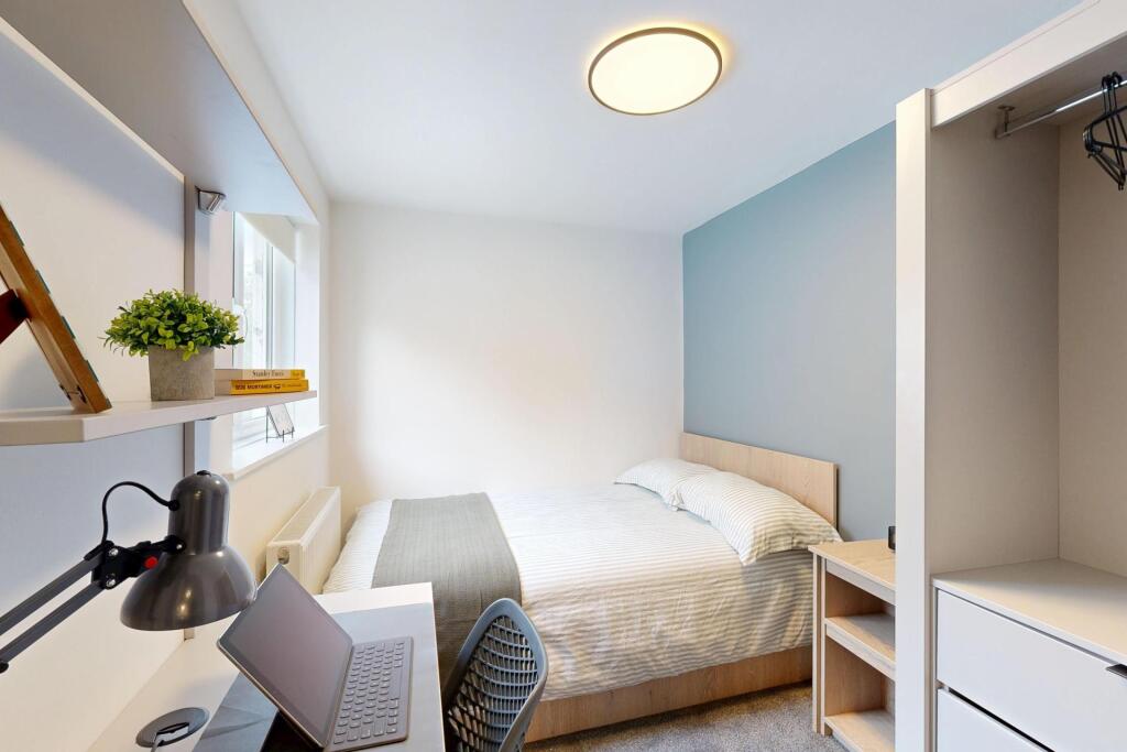 A bright and tidy single bedroom featuring a co...