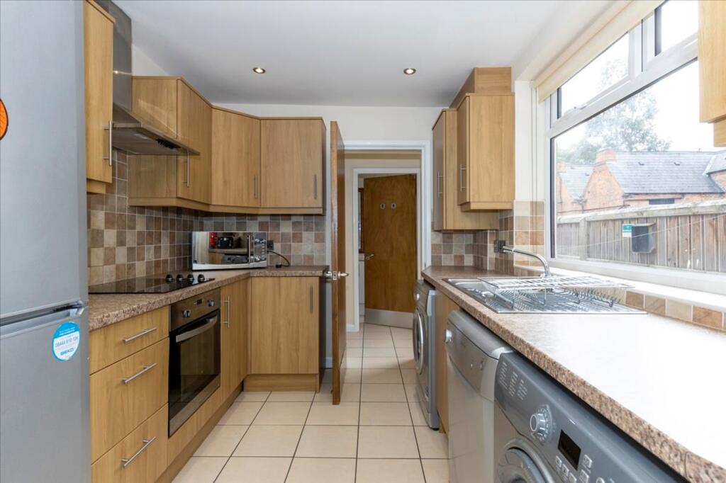 This modern kitchen features stylish wooden cab...