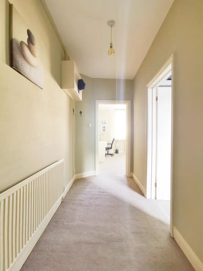 Bright and clean hallway with neutral tones and...