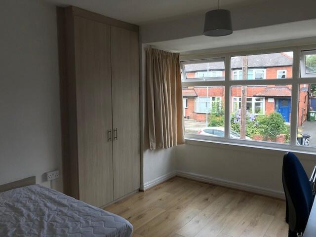 A bright and clean bedroom with a large window ...