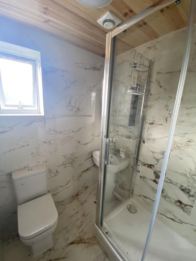 A modern bathroom featuring a walk-in shower wi...