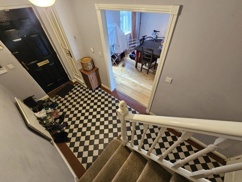 Bright and tidy hallway with patterned floor ti...