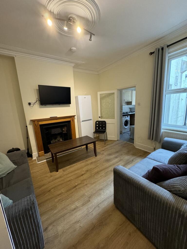 A spacious, well-maintained living room featuri...