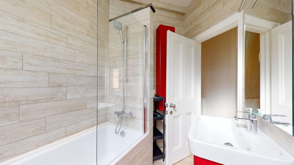 Bright and modern bathroom suite featuring a st...