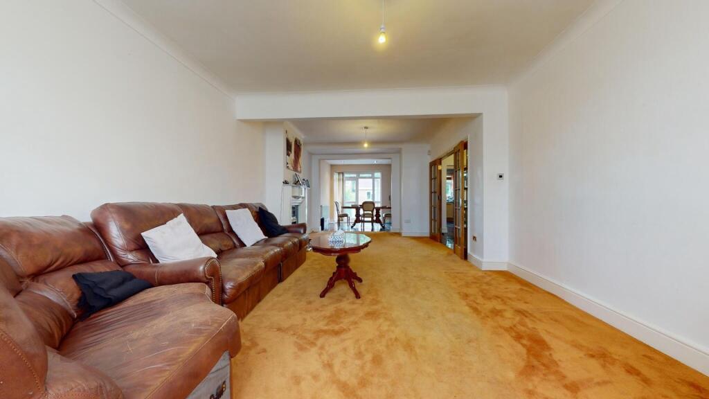 A spacious living room featuring a large brown ...