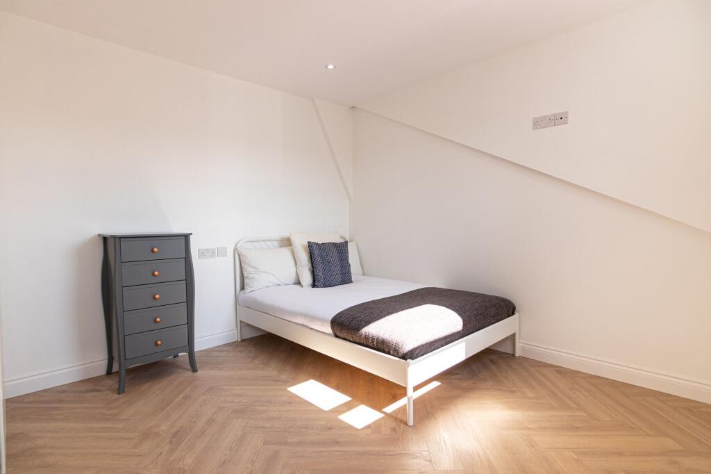 A spacious and well-lit double bedroom featurin...