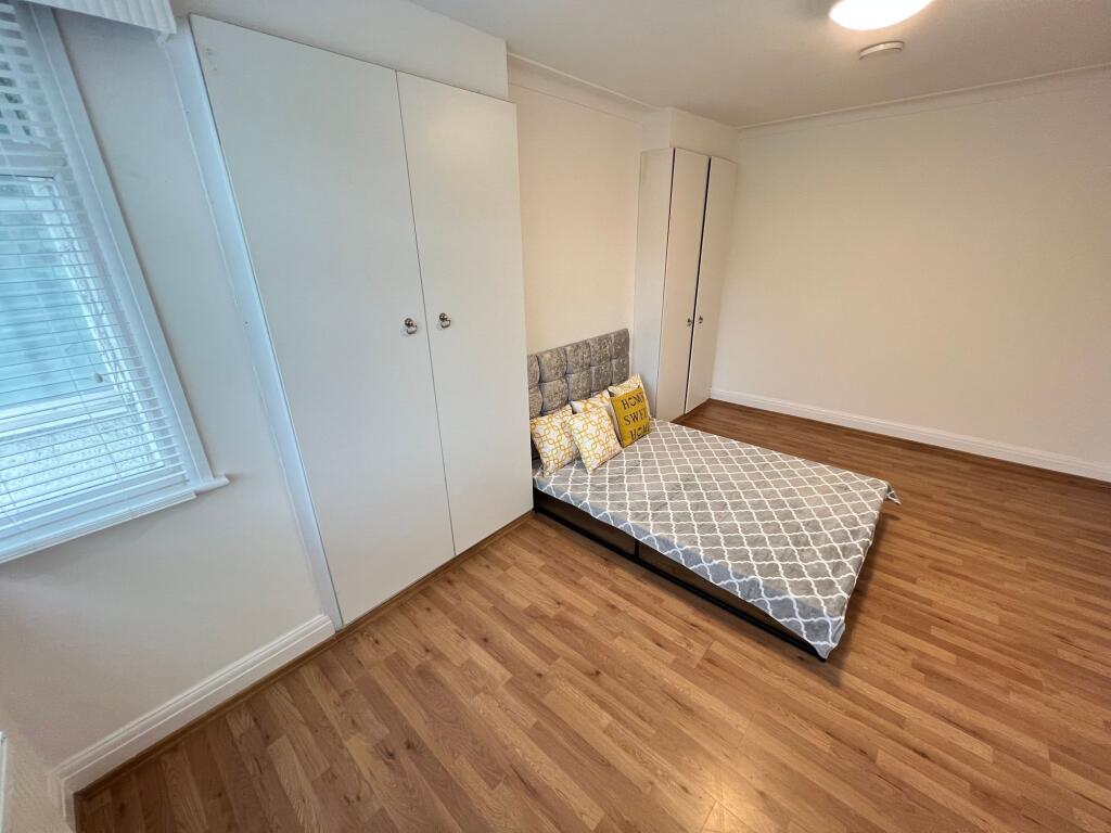Bright and tidy double bedroom featuring wood-e...