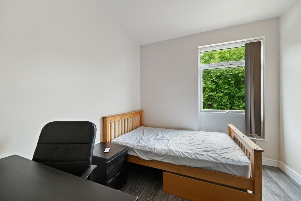 A bright and tidy single bedroom featuring a co...