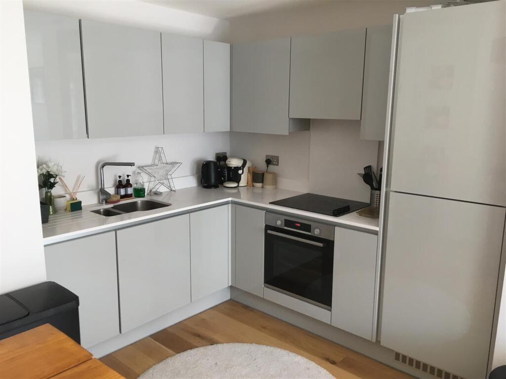 Modern and sleek kitchen featuring light grey c...