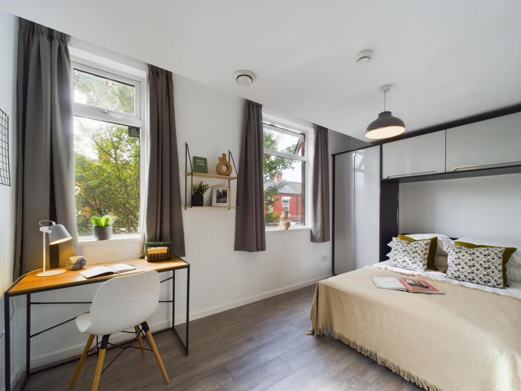 A bright and inviting double bedroom with a coz...