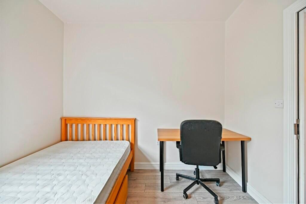 A neat and simple single bedroom featuring a wo...