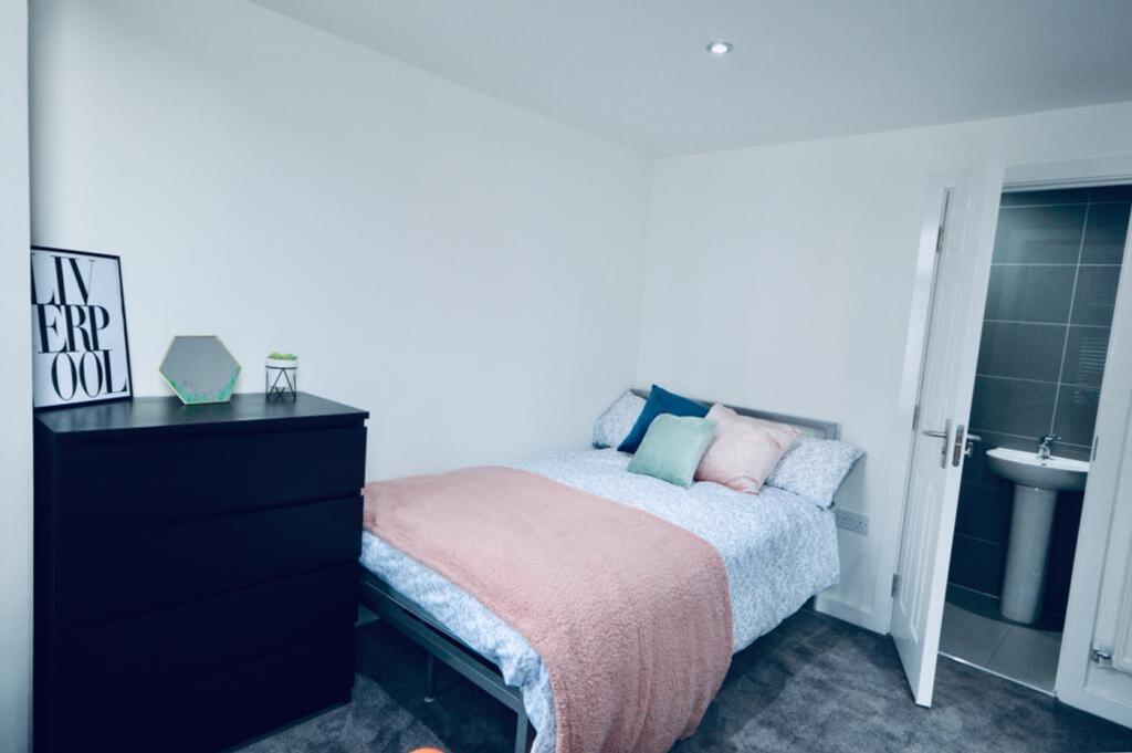 A bright and tidy double bedroom featuring mode...