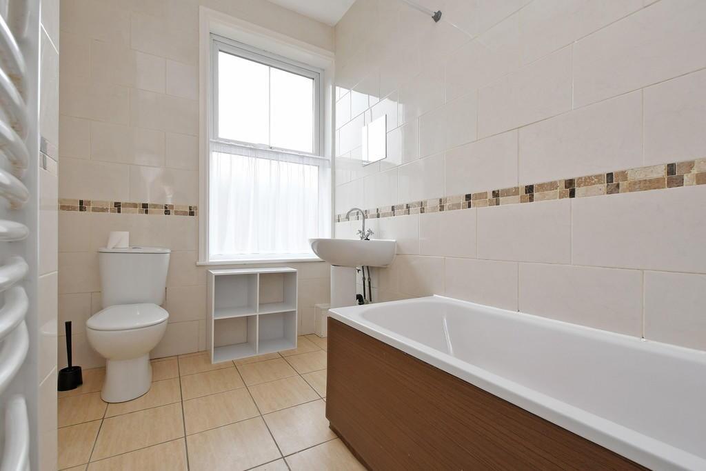 Bright and clean bathroom suite featuring a lar...