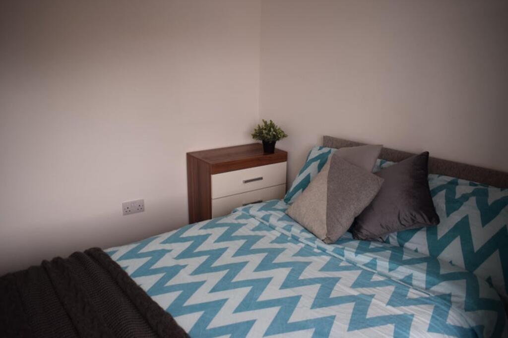 This cozy double bedroom features a modern desi...