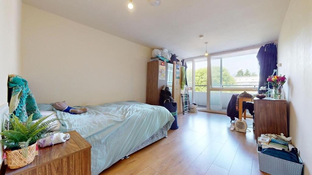 A bright and airy bedroom featuring a large win...