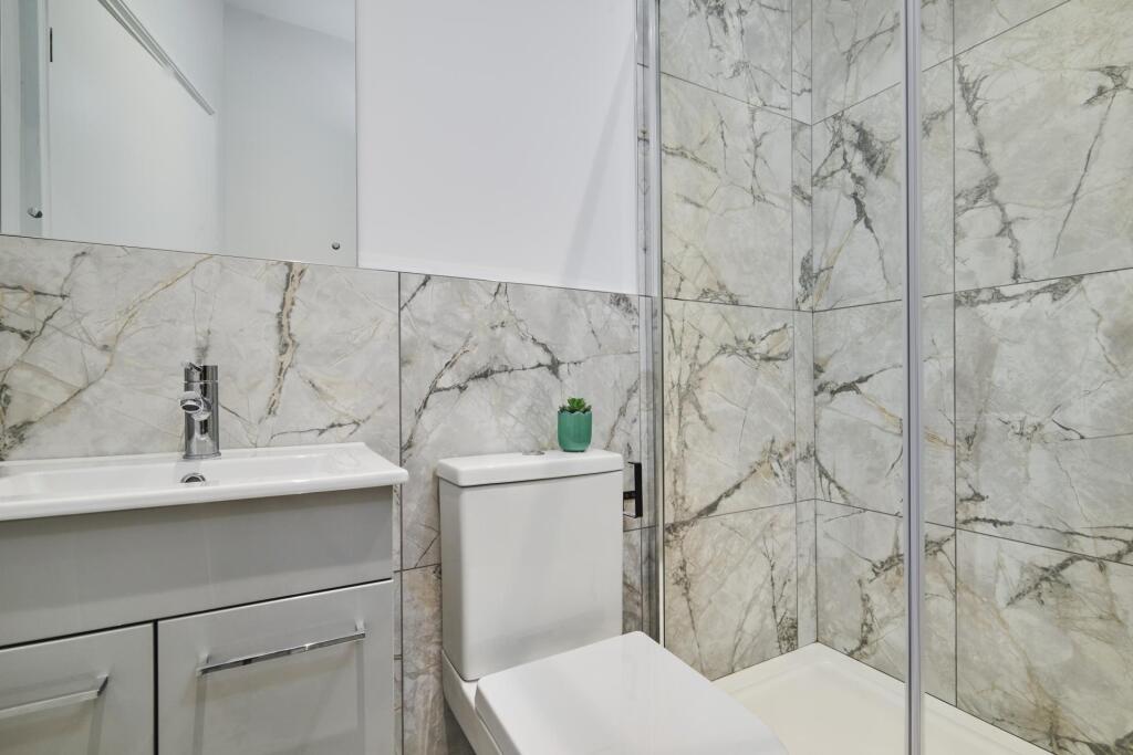 A modern bathroom featuring a white toilet and ...