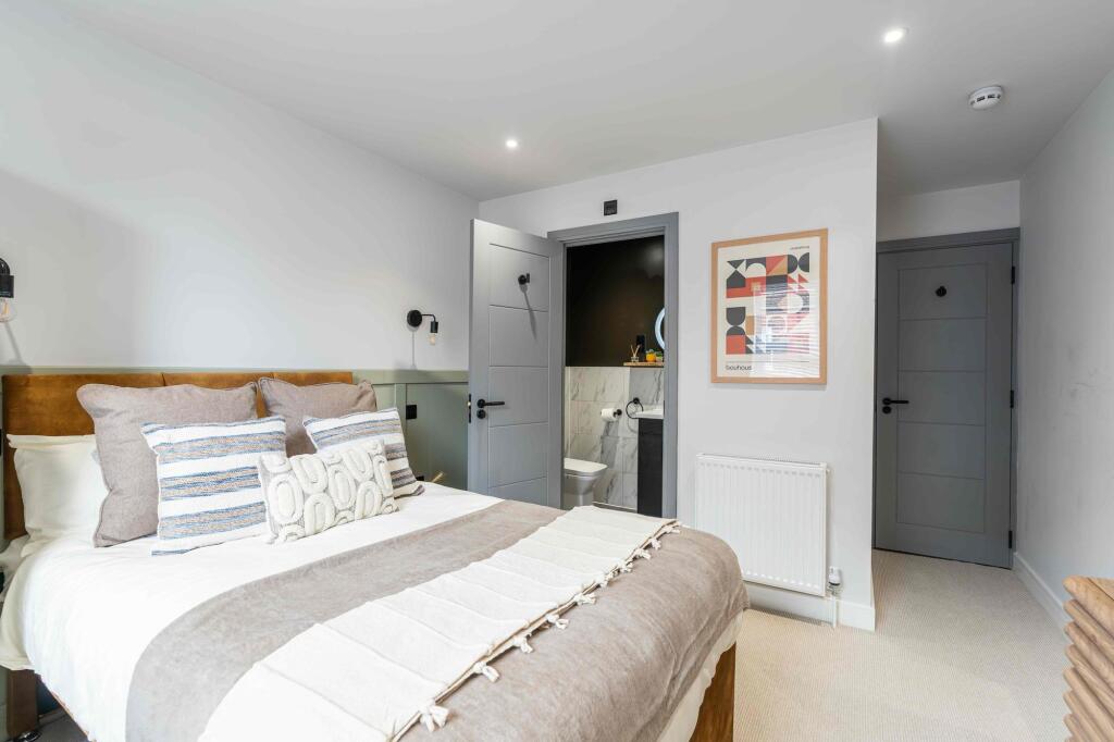 A modern, well-presented bedroom featuring a la...