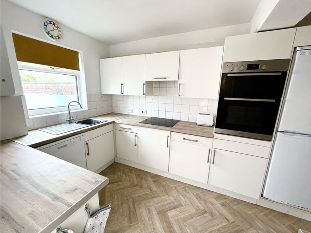 A bright and modern kitchen featuring ample sto...