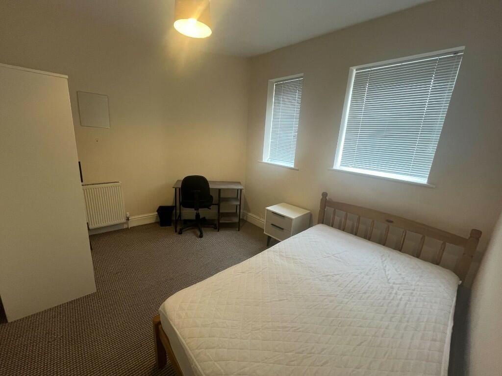 A clean and simple double bedroom featuring a d...