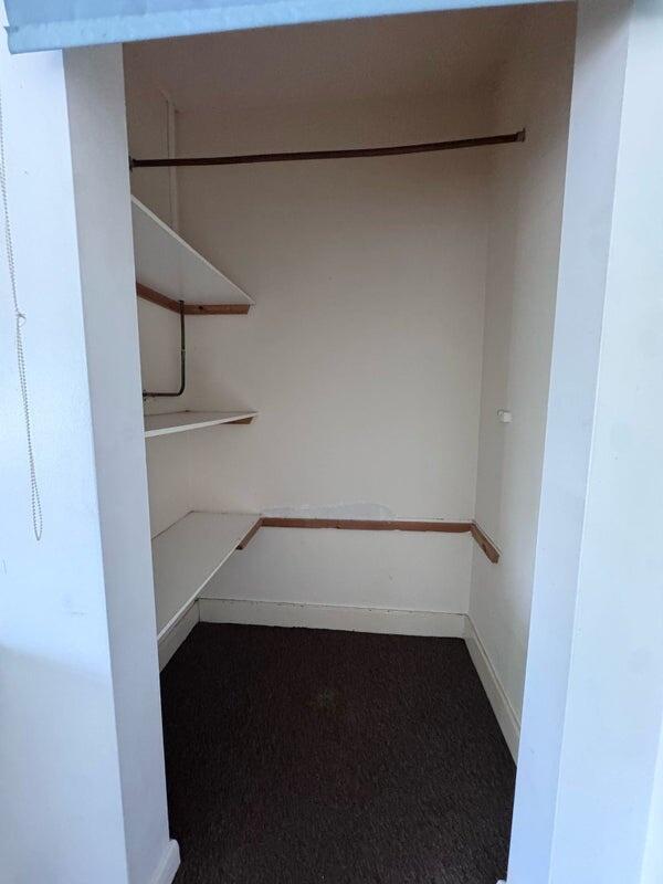 A compact storage area featuring wall-mounted s...