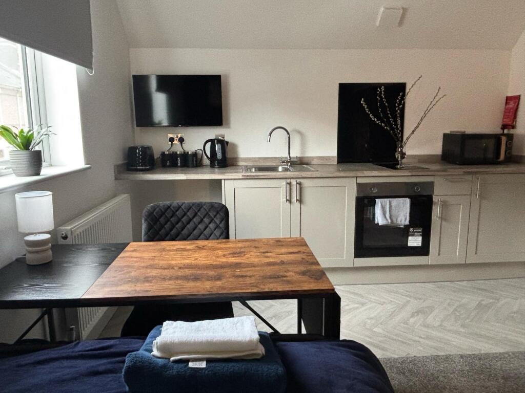 This modern kitchen area features sleek cabinet...