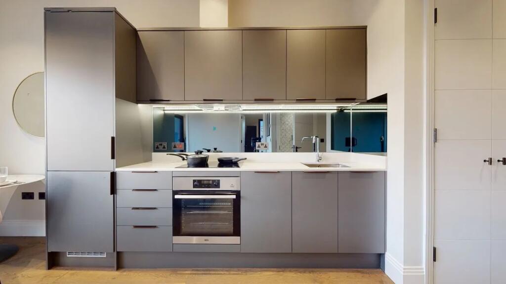 A sleek, modern kitchen with minimalist grey ca...
