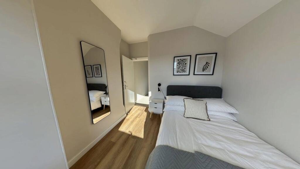 A bright and modern double bedroom featuring a ...