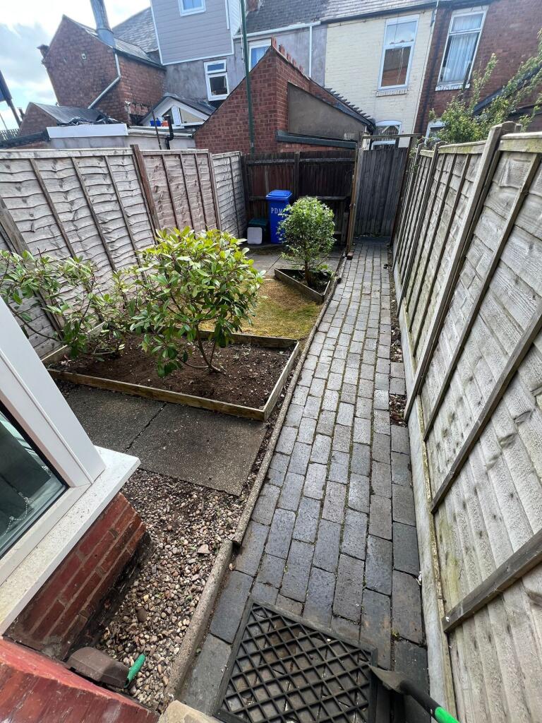 Well-maintained garden with paved pathway, bord...