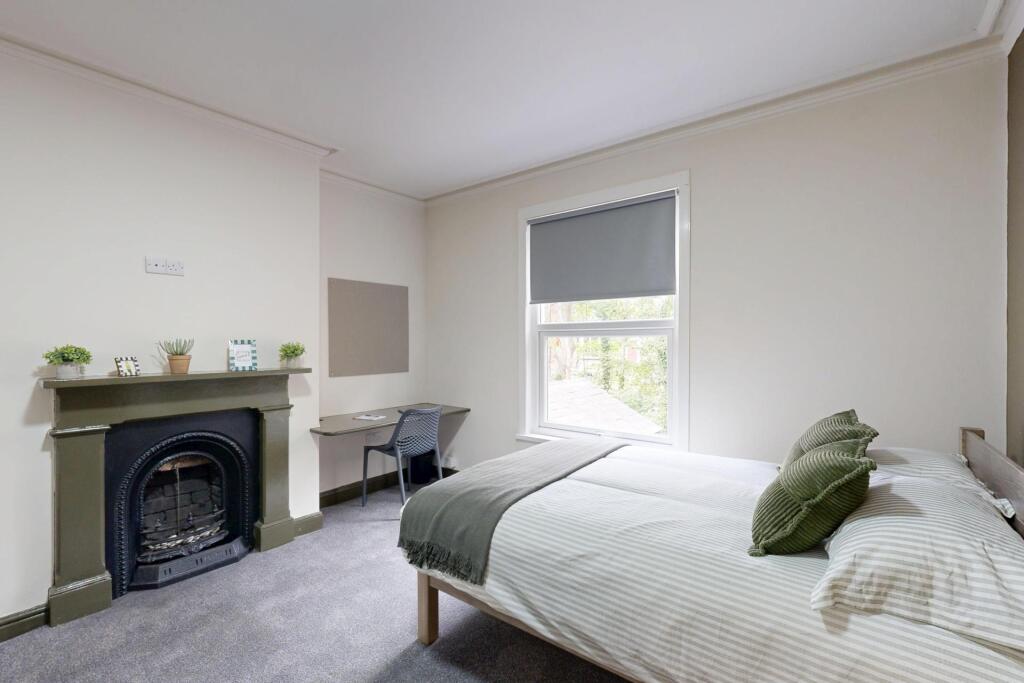 A spacious and well-lit master bedroom featurin...