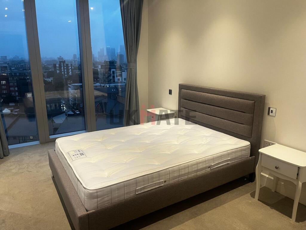 A spacious, modern bedroom with a large window ...