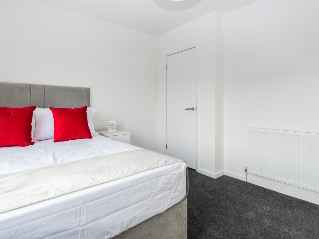 A bright and clean double bedroom featuring a c...