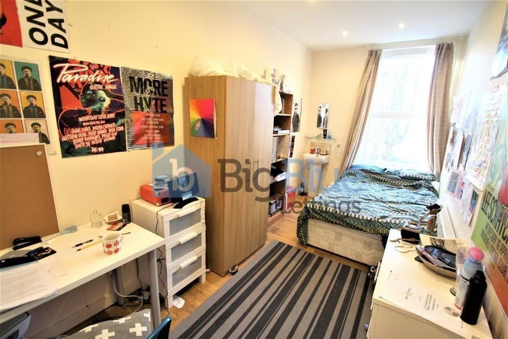 A cozy and well-organized single bedroom featur...