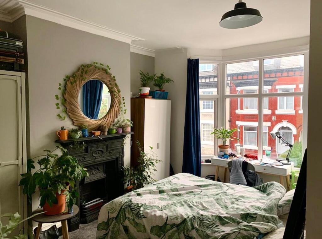 A bright, nicely maintained bedroom featuring a...