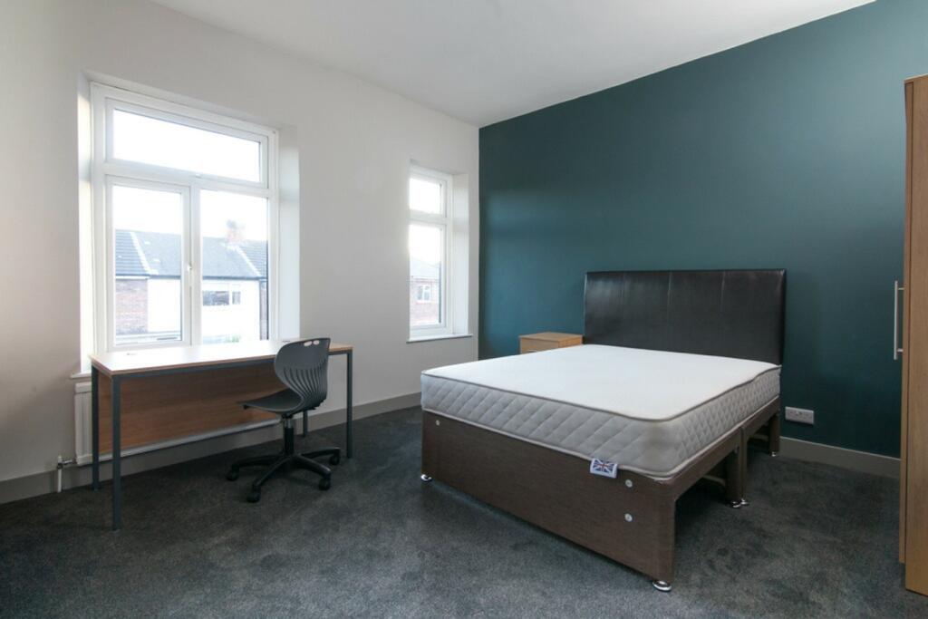 A spacious and well-lit double bedroom featurin...