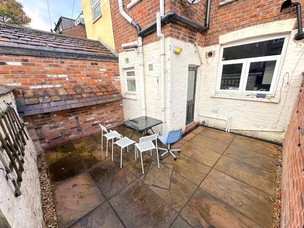 Private paved rear courtyard with simple outdoo...