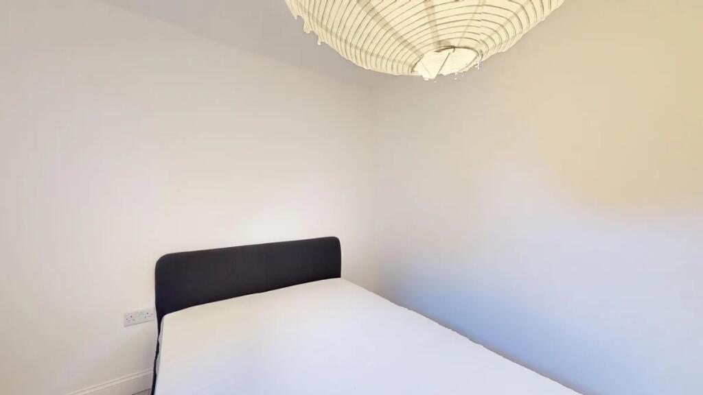 A simple and tidy double bedroom featuring a ne...