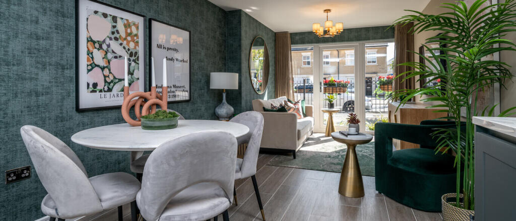 Modern living room with dark green textured walls, grey furniture, gold accents, and large glass doo