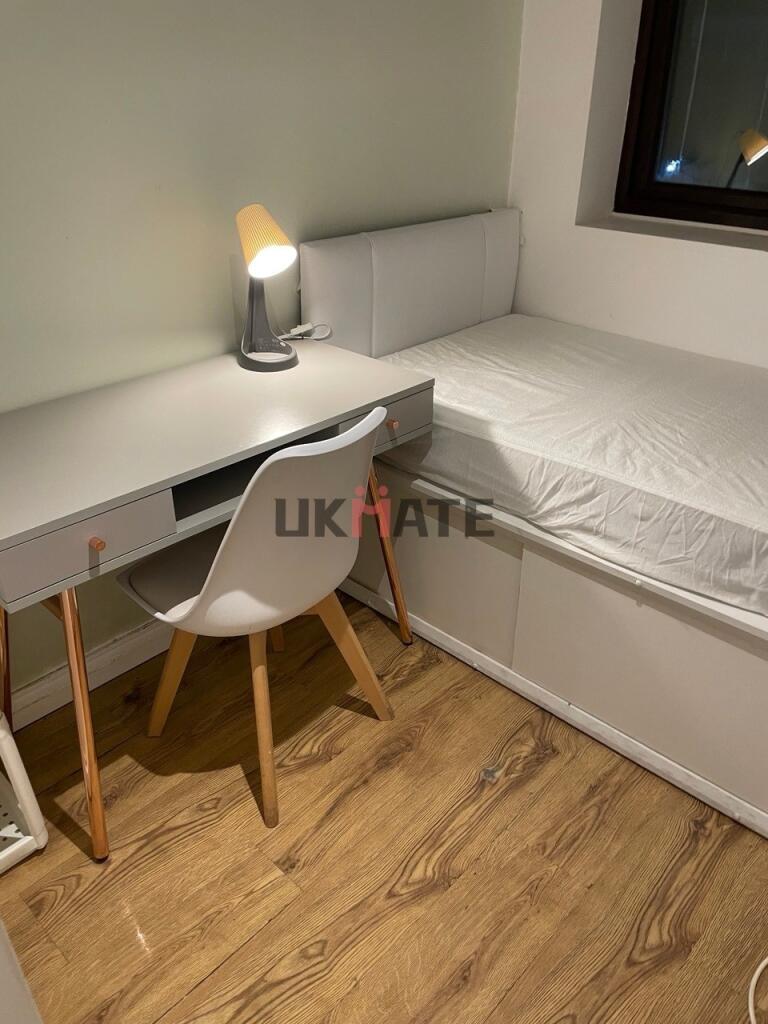 A cozy single bedroom featuring a simple bed, a...