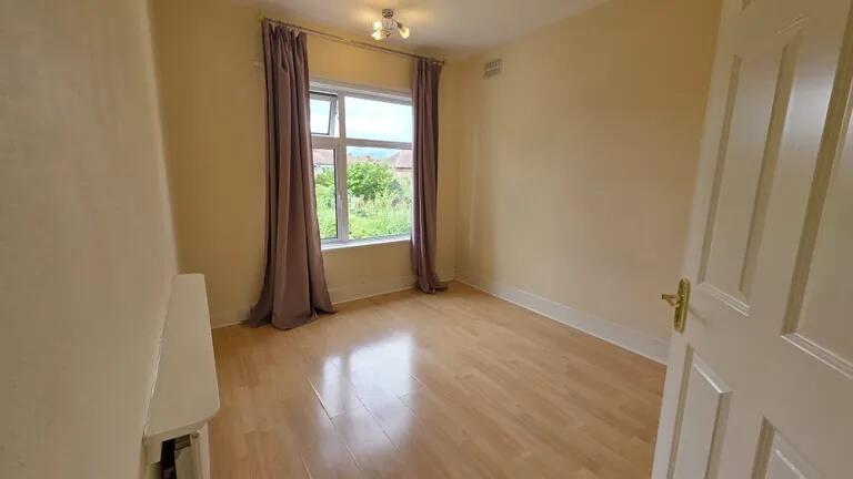 A bright and tidy single bedroom featuring ligh...