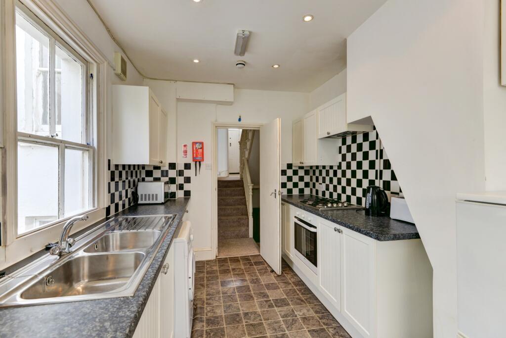 Bright and tidy kitchen featuring modern checke...