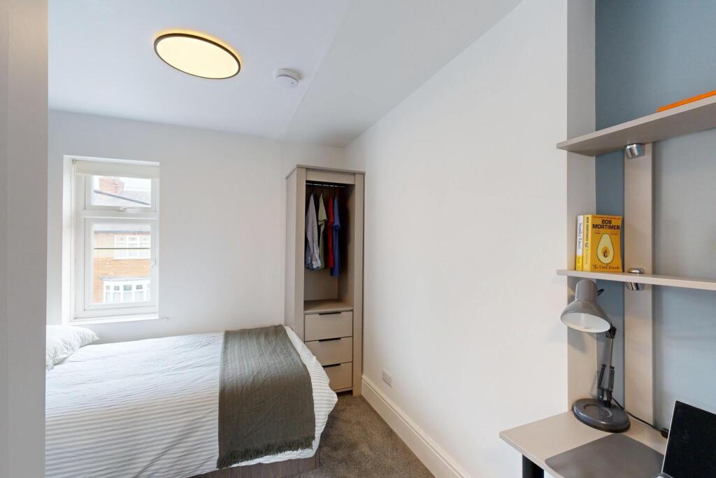 A clean, well-lit bedroom featuring a comfortab...