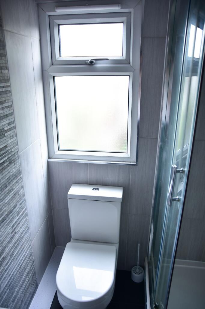 A modern, clean bathroom featuring a white toil...
